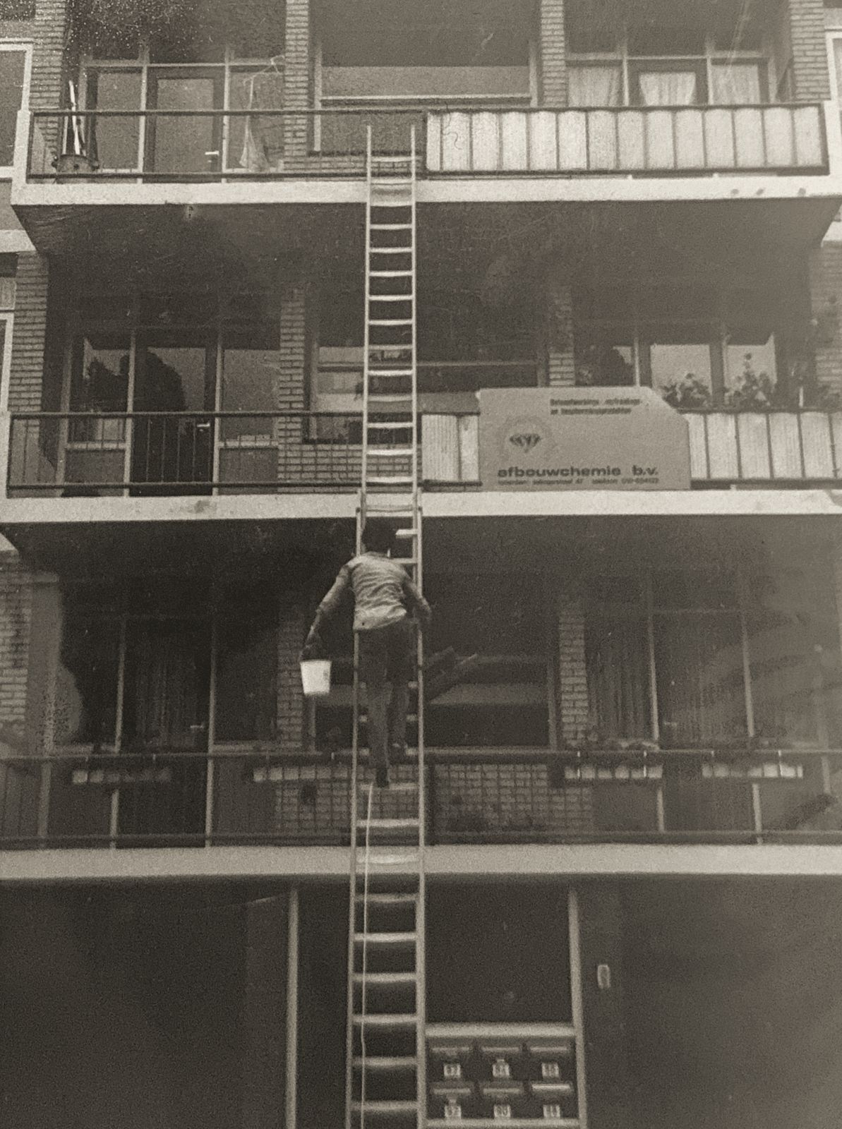 Collega klimt via de ladder langs de gevel